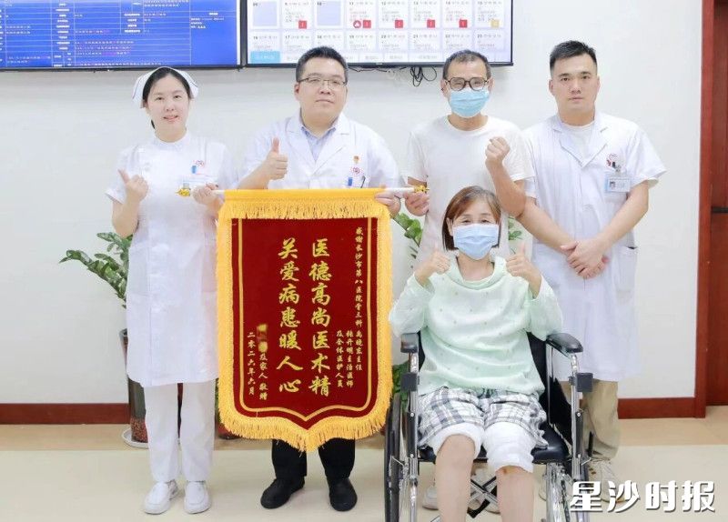 患者在出院前和医护人员进行合影,并赠送锦旗。
