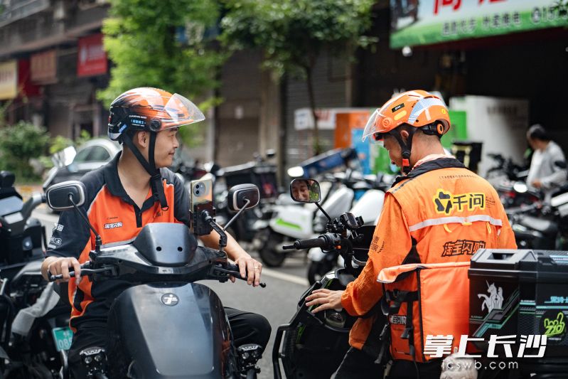 骑手刘旭(左)在送外卖订单。 湘江早报全媒体记者 罗钟杰 摄