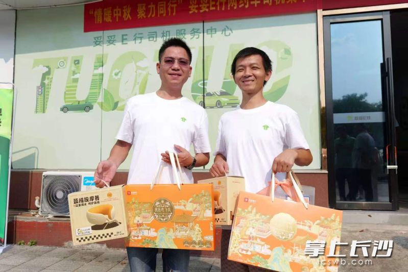 网约车司机王磊(左)领取工会组织送来的节日慰问礼包。湘江早报全媒体记者 范龙贵 摄